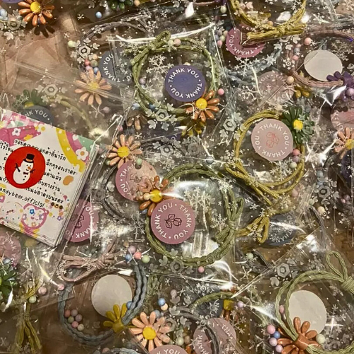 Souvenirs: Daisy hair bands packed in cute clear plastic bags with thank you stickers
